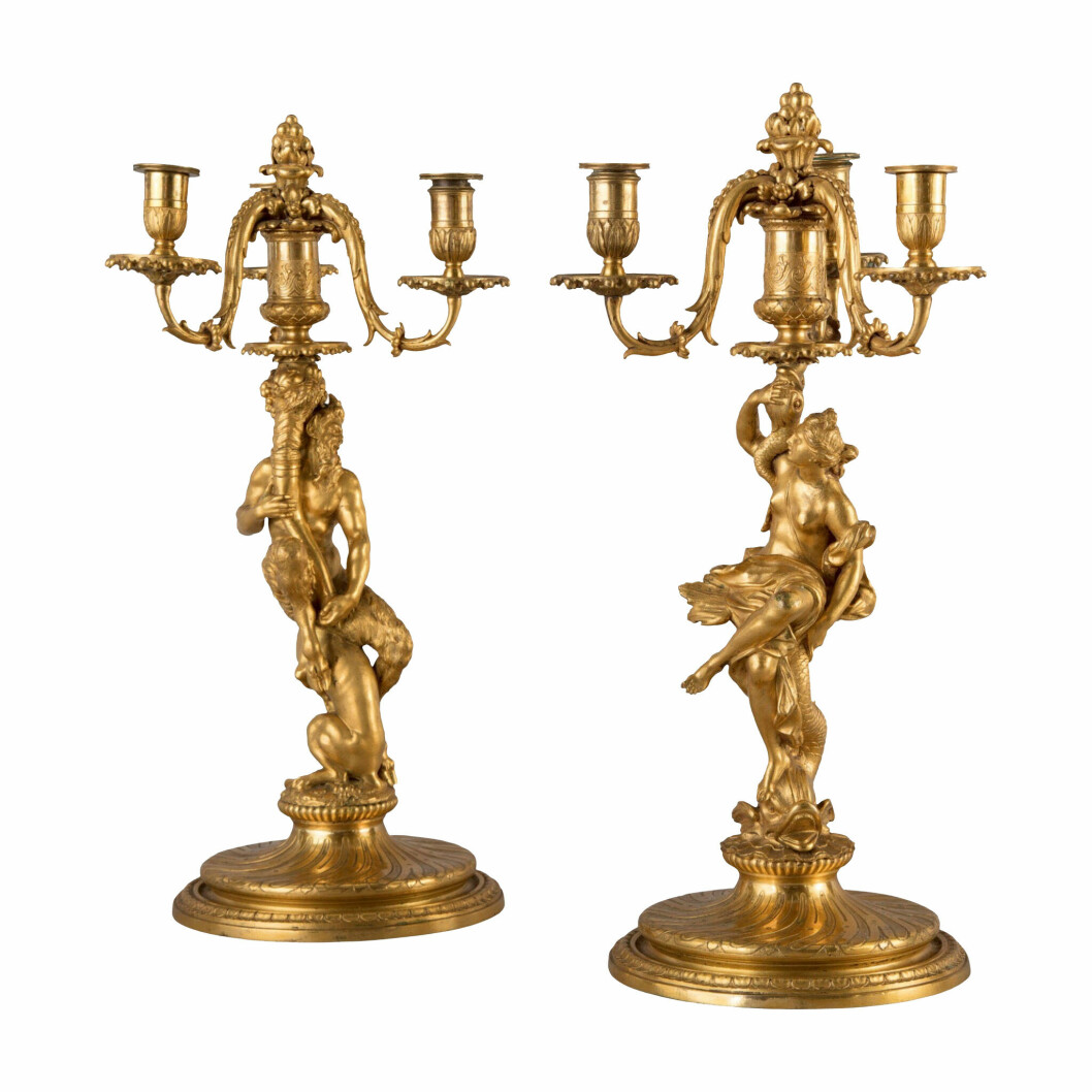 Det överdådigt dekorerade paret kandelabrar av brons är ritat av den franske skulptören Corneille van Clève (1645–1732). van Clève är känd för sina ritningar till modeller av ljusstakar och kandelabrar, som hans svåger guldsmeden Nicolas de Launay (1647–1727) sedan tillverkade av silver. Sannolikt är även ritningen till auktionens par ursprungligen avsedd för silver. Högsta bud inklusive avgifter resulterade i priset 68750 dollar 2019 hos Sotheby’s. Två överdådigt dekorerade kandelabrar i brons.