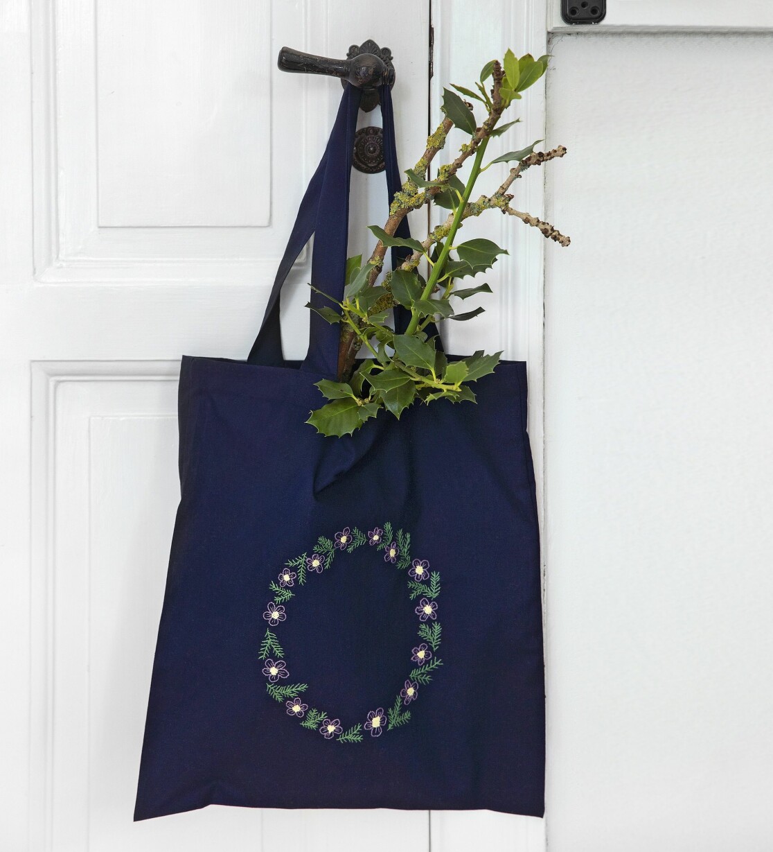 Sy en söt blomsterkrans på julens shoppingbag. Även söt som dekoration när den inte används. Kasse med broderad blomsterkrans.
