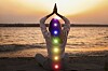 Young woman meditating on beach near river at sunset, back view. Scheme of seven chakras, illustration; Shutterstock ID 2105462699; purchase_order: 123; job: ; client: ; other: