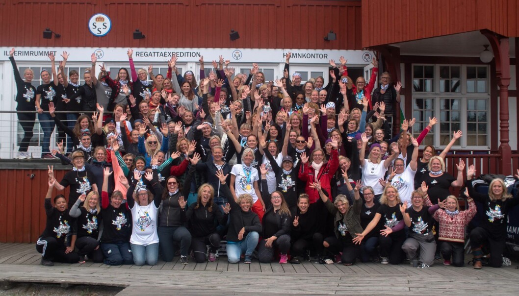 2019 deltog 130 kvinnor i en She Captain-eskader med 30 båtar. Det är världens största helt kvinnliga eskader, enligt Anna. Foto: She Captain 130 kvinnor aktiva i nätverket She Captain framför ett hamnkontor i Stockholms skärgård.