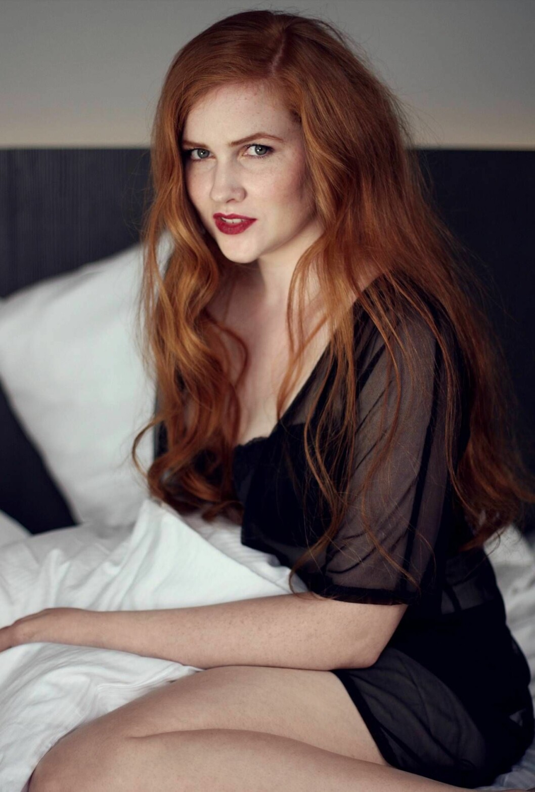 Charlotte som modell i en säng.
