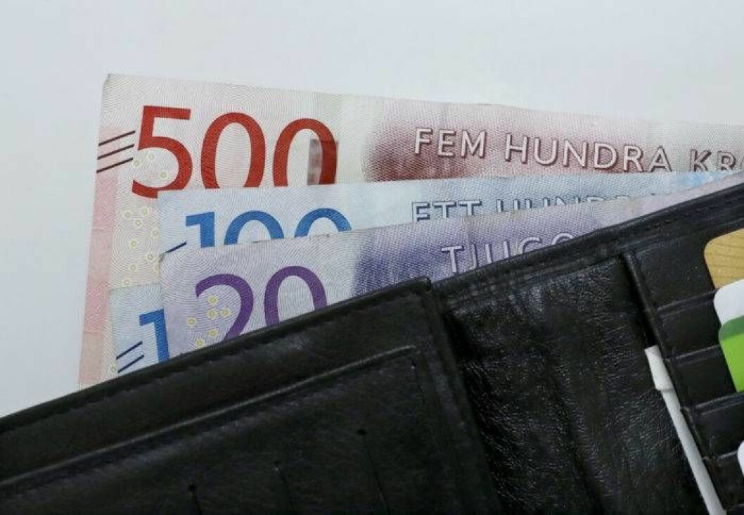 Svenska sedlar som sticker upp ur en svart läderplånbok.