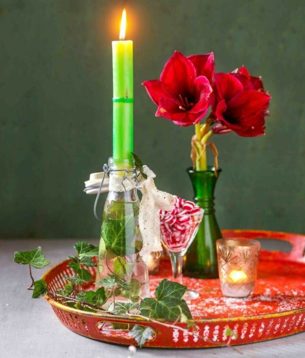 Två i ett – både blomma och ljus. Foto: Anders Norrsell Glasflaska med murgruna och ljus.
