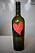 En flaska rödvin med ett rött hjärta på.