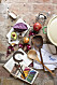 Ett bord med träslevar, rödkål, avokado, pepparkorb i glasburk, granatäpple och informationsbroshyr om växtfärgning.