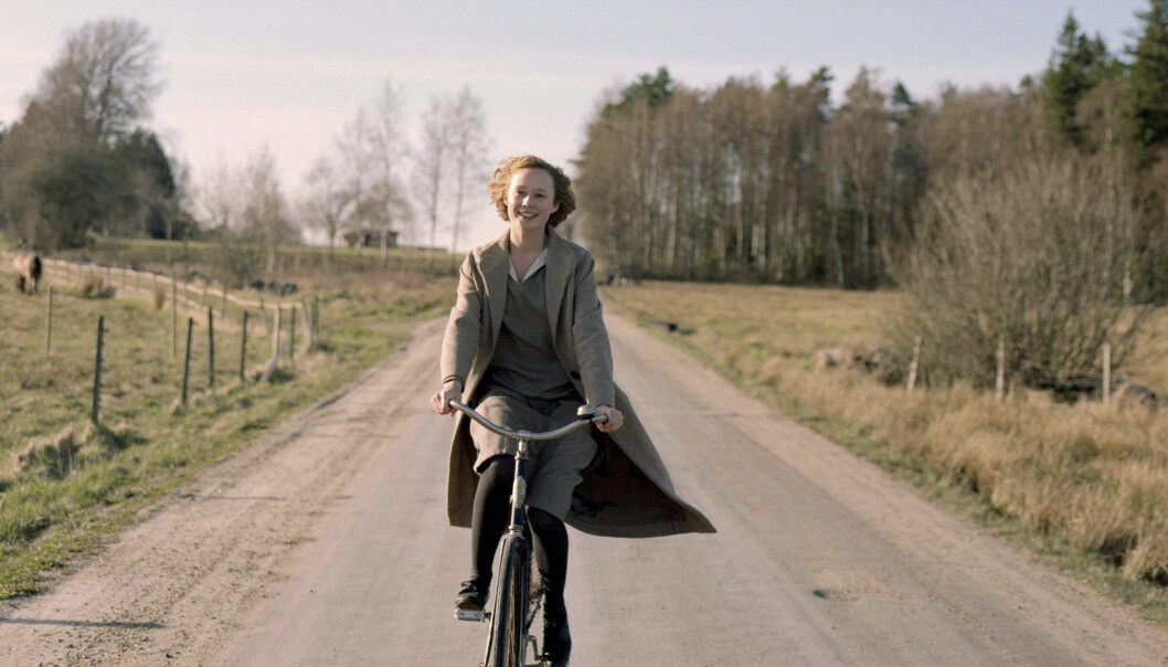 Alba August fick sitt genombrott i filmen <i>Unga Astrid</i> 2018. Foto: Nordisk film Alba spelar Astrid Lindgren, här glad på cykel.