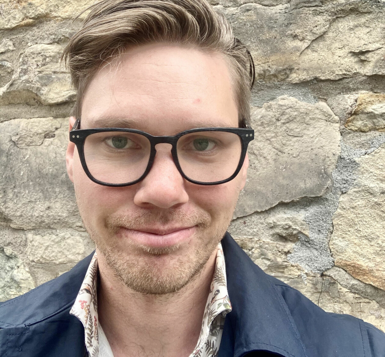 Alexander Bygdén fotograferad mot en stenvägg.