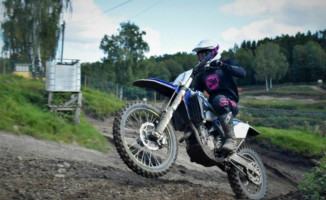 Totalt fokus gäller när man kör motocross, annars finns risken att man kör omkull. Foto: Jonas Olsson En kvinna kör motocross uppför en lerig backe.