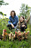 Musikerna Ann-Sofie och John Hoyles sitter på huk i grönskan med sina höns.