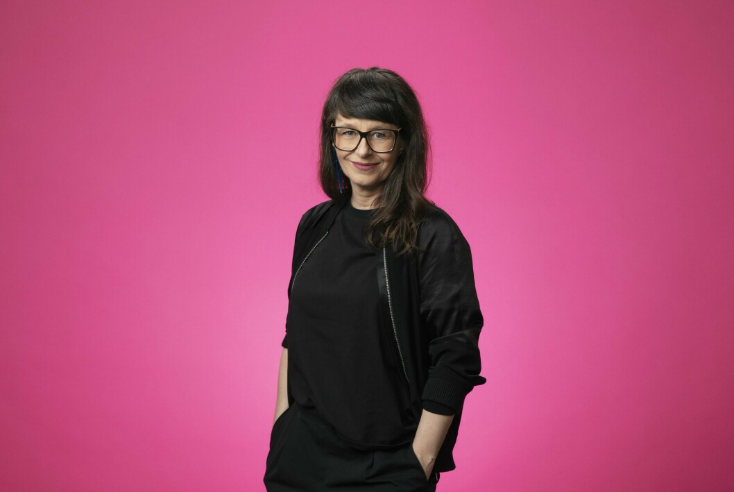 – Det känns som att hela livet, yrkeserfarenheterna och drömmarna har kokat ned till just det här. Det är en stor lyckokänsla att få ta över Melodikrysset! säger Anna Charlotta Gunnarson. Programledaren Anna Charlotta Gunnarson står svartklädd, med händerna i fickorna, mot rosa bakgrund.