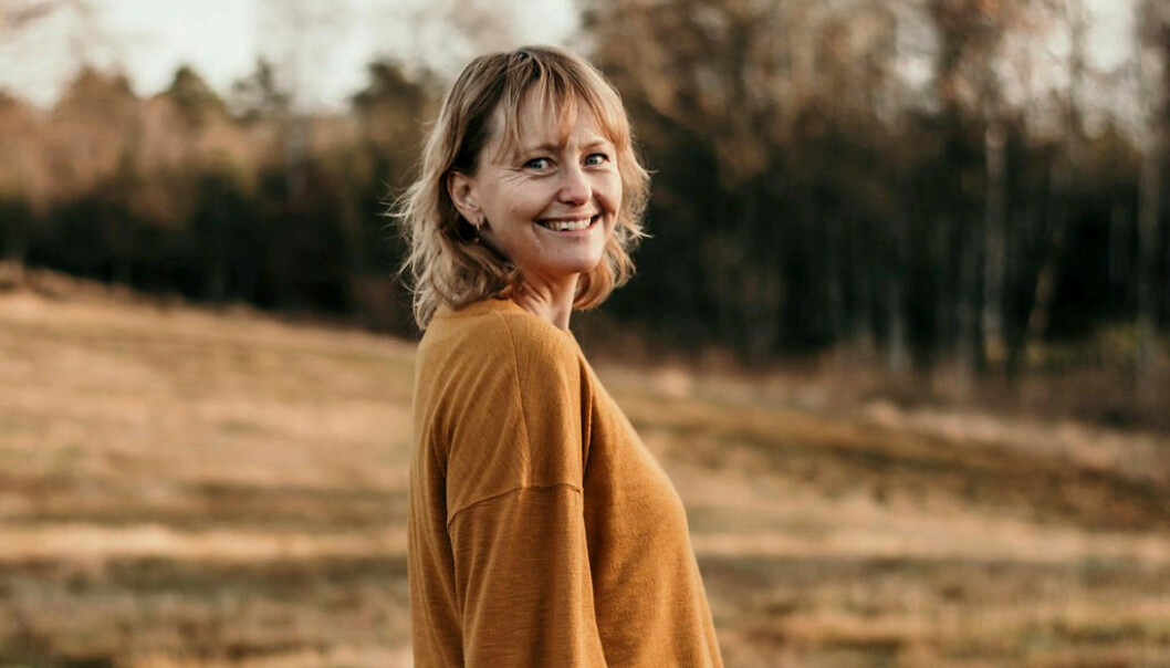 Anna Tallwe utomhus, hon har på sig en senapsgul tröja.