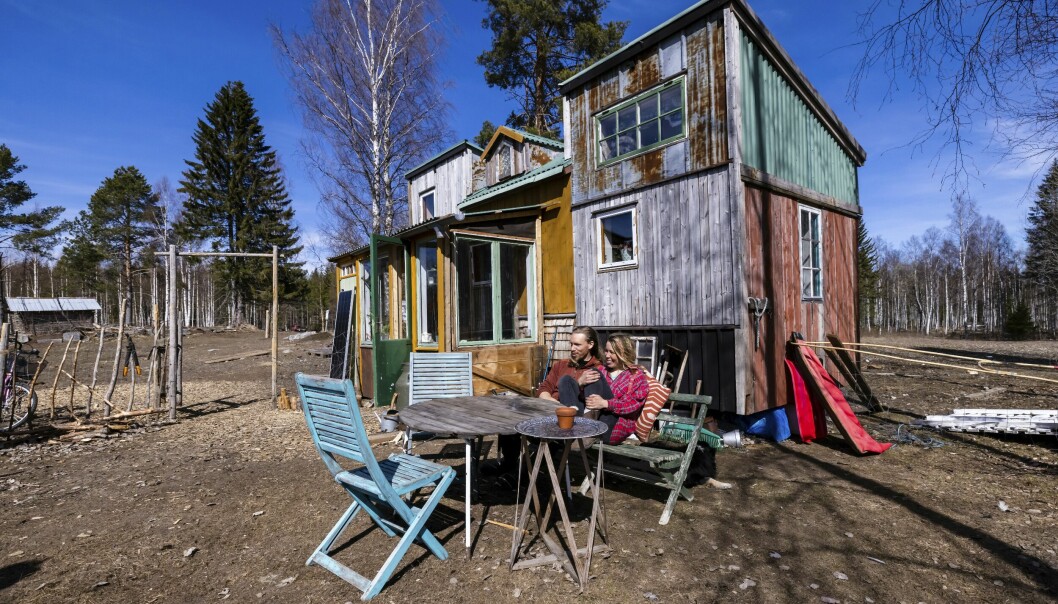 Henrik och Anna sitter på trädgårdsmöbler utanför minihuset och berättar om att hela huset är byggt av återbruk.