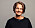 Företagsledaren Anne Kilhgren fotograferad mot en grå bakgrund. Hon är klädd i svart och tittar leende in i kameran.
