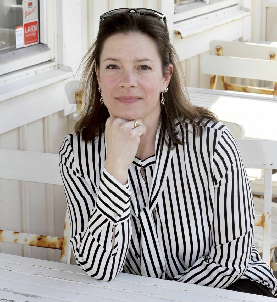 Anne Liv med handen i hakan på en uteservering