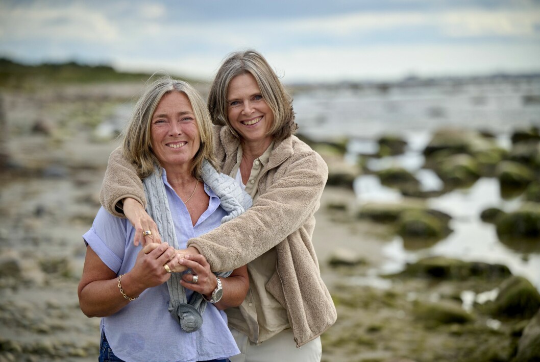 Birgitta Hågemark Olshov håller om Annika Erlandsson Olshov där de leende står på stranden i Viken vid Öresund.