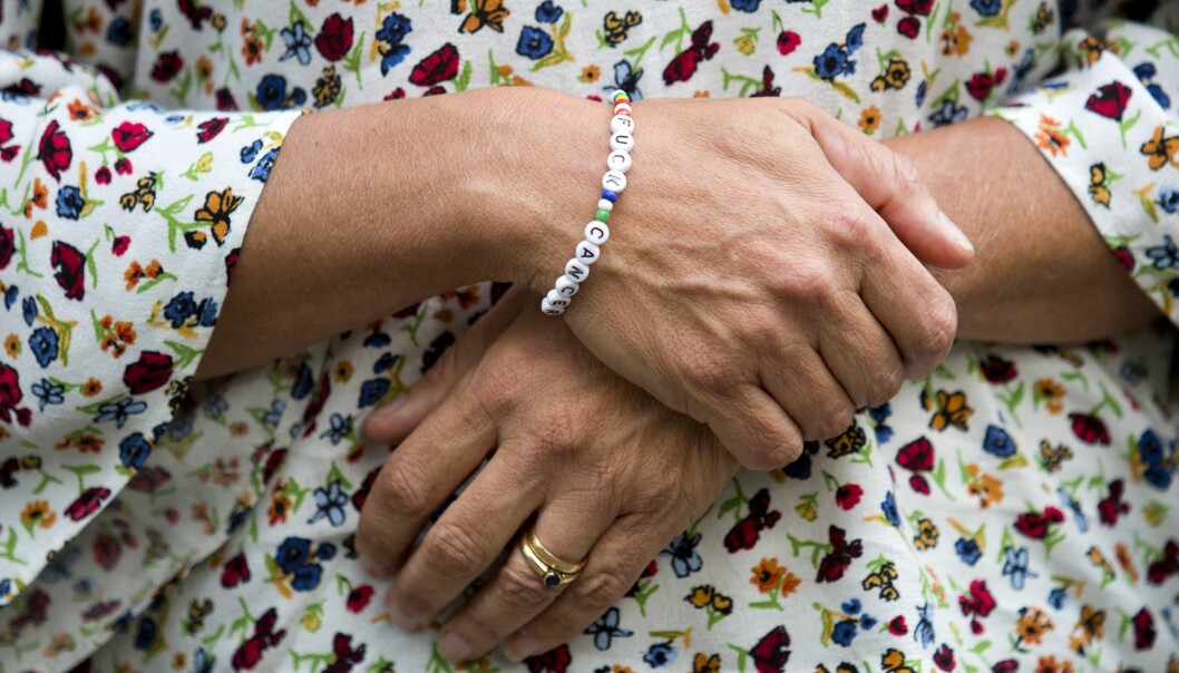 Arm med pärlarmband med texten Fuck cancer.