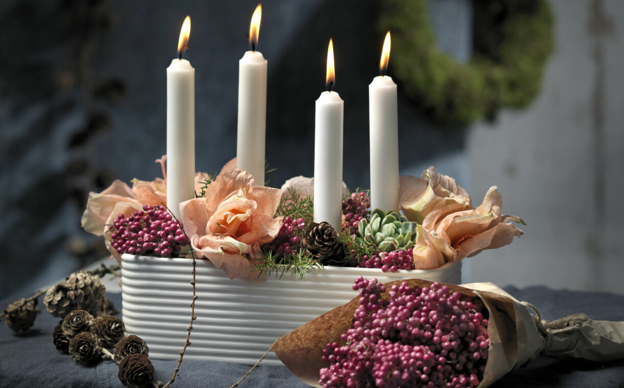 Arrangemang med torkad amaryllis och levande ljus.