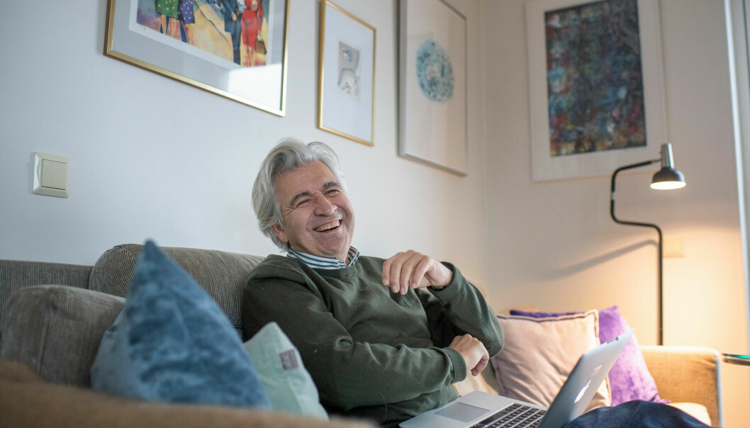 Artur Ringart sitter i soffan och skrattar.