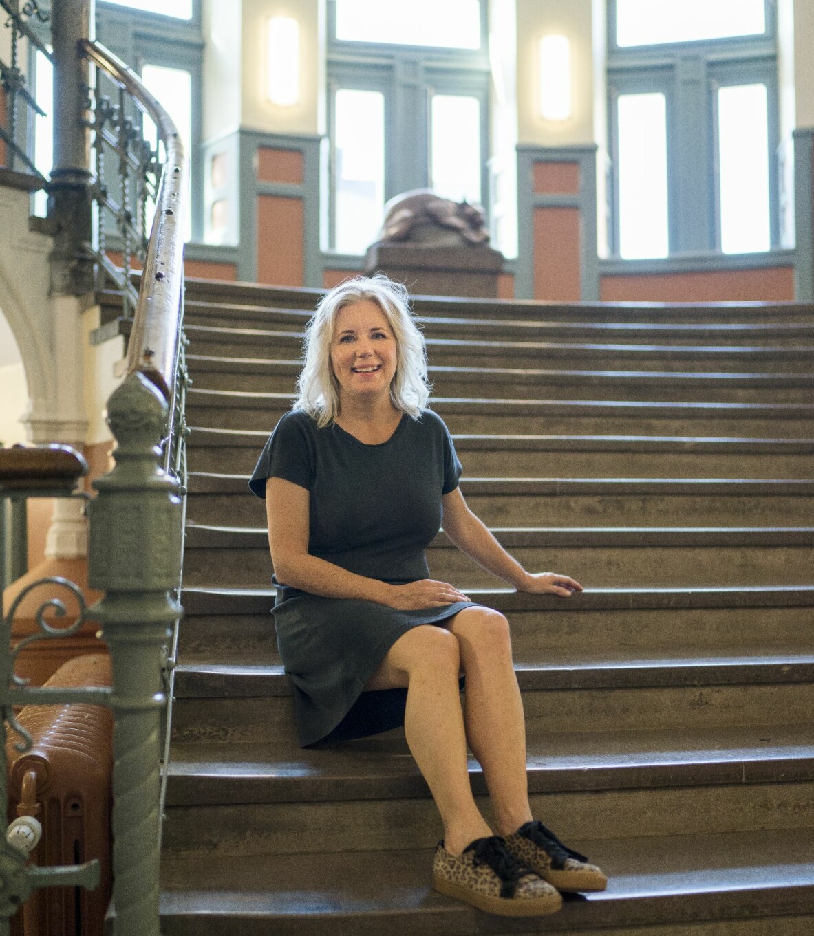 Åsa Rasmussens på skoltrappan inne i stan. Glad Åsa sitter i den gamla, fina skoltrappan.