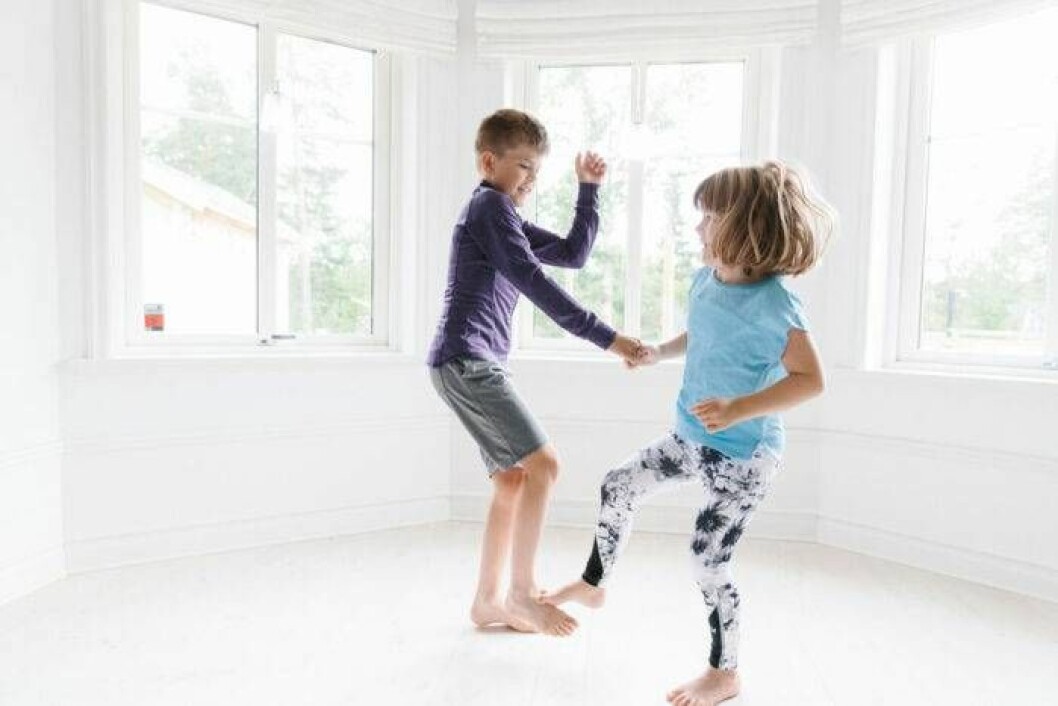 Två barn som tränar balans tillsammans.