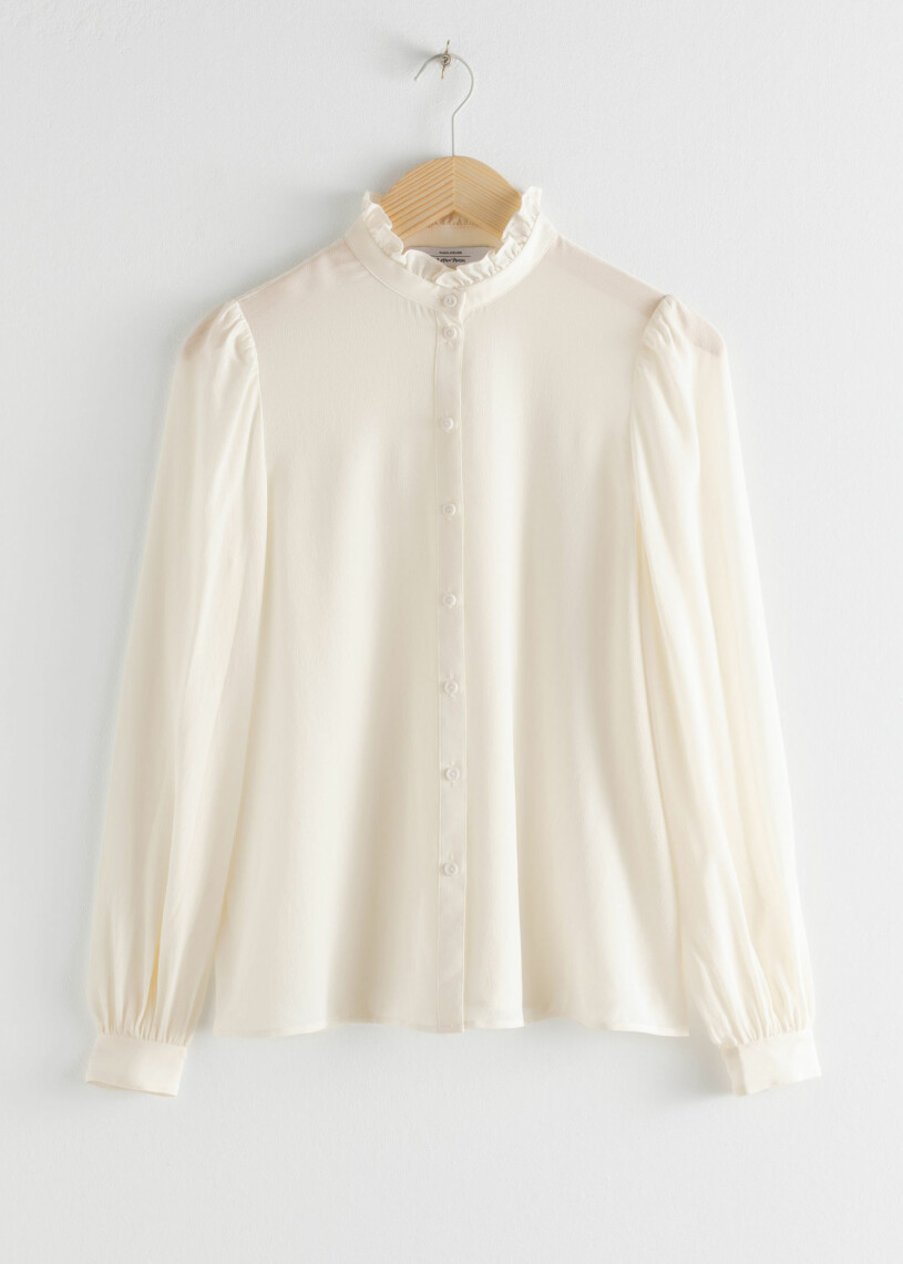 Beige blus med detaljer.