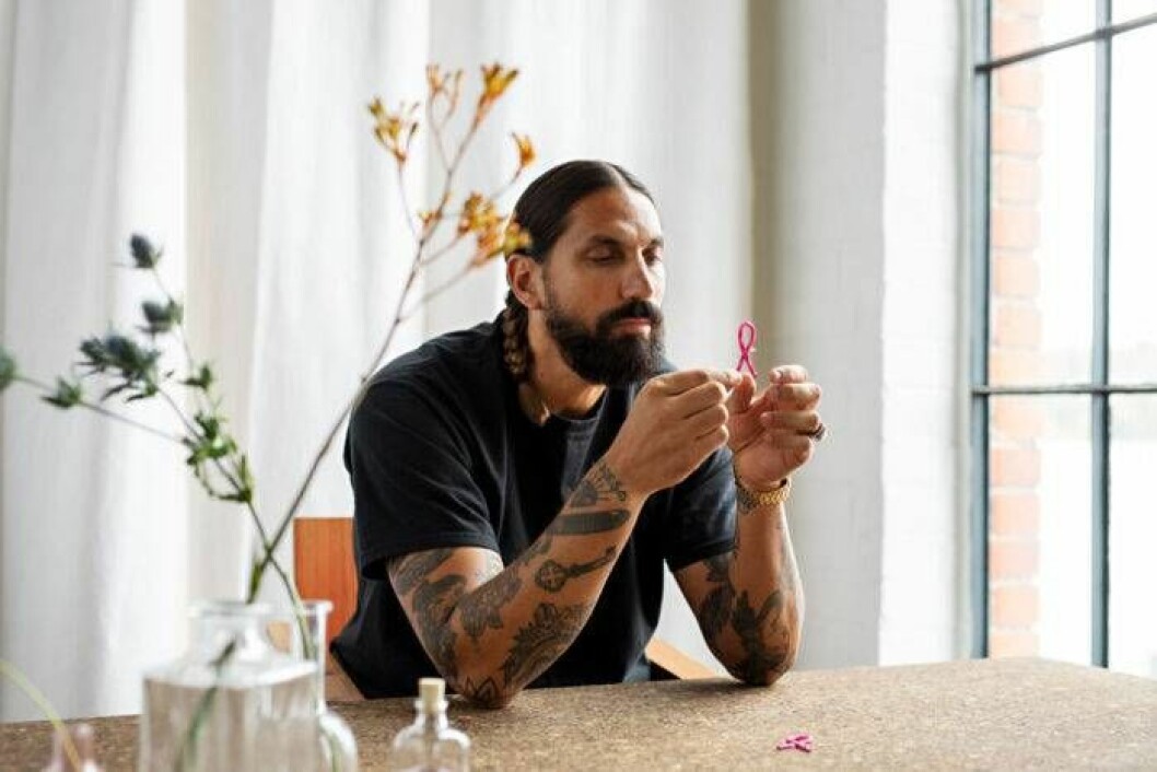 Ben Gorham, mannen bakom Byredo och 2019 års Rosa band. Ben Gorham, mannen bakom Byredo och 2019 års Rosa Bandet, sitter vid ett skrivbord med året srosa band i sinhand