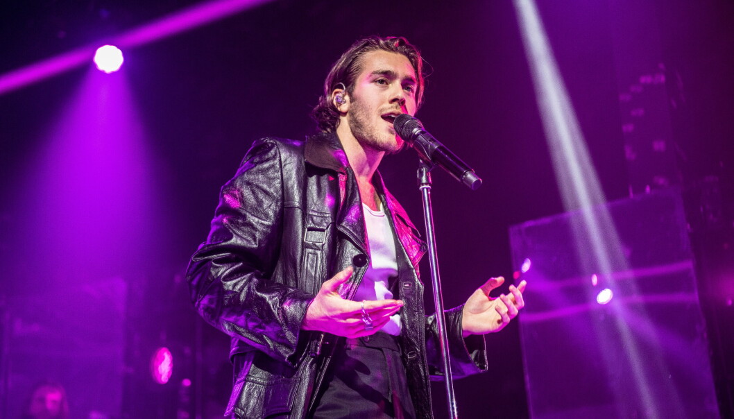 Benjamin Ingrosso, iklädd svart skinnjacka, uppträder på en spelning.
