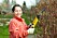 kvinna klipper bort döda grenar från buske