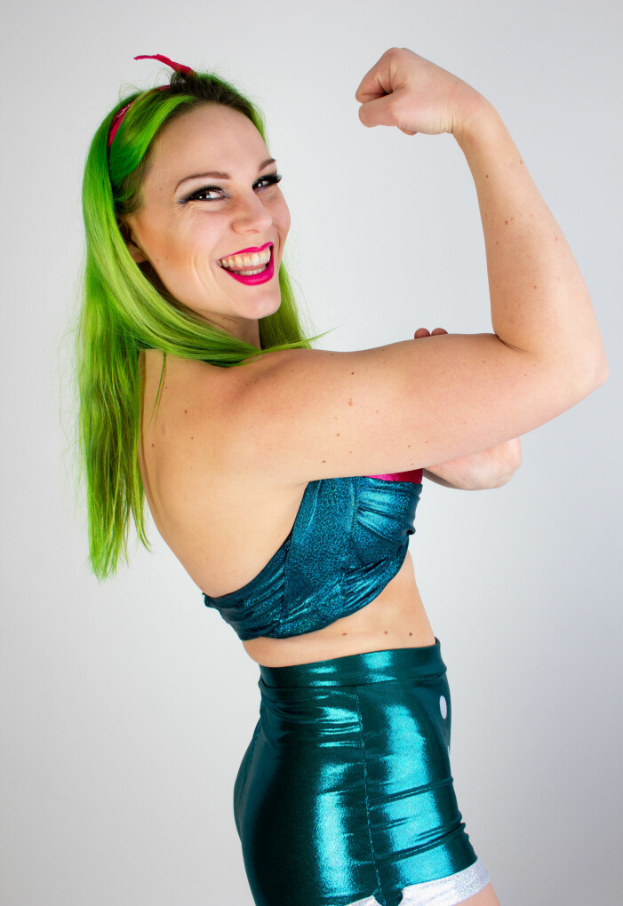 Tillsammans med sina tränare har Linnéa Runhage utvecklat karaktären Betty Rose, som har egna personlighetsdrag och egenskaper. Wrestlaren Linnéa Runhage som Betty Rose, i pinup-stil och grönt hår, spänner biceps och ler stort.