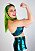 Wrestlaren Linnéa Runhage som Betty Rose, i pinup-stil och grönt hår, spänner biceps och ler stort.