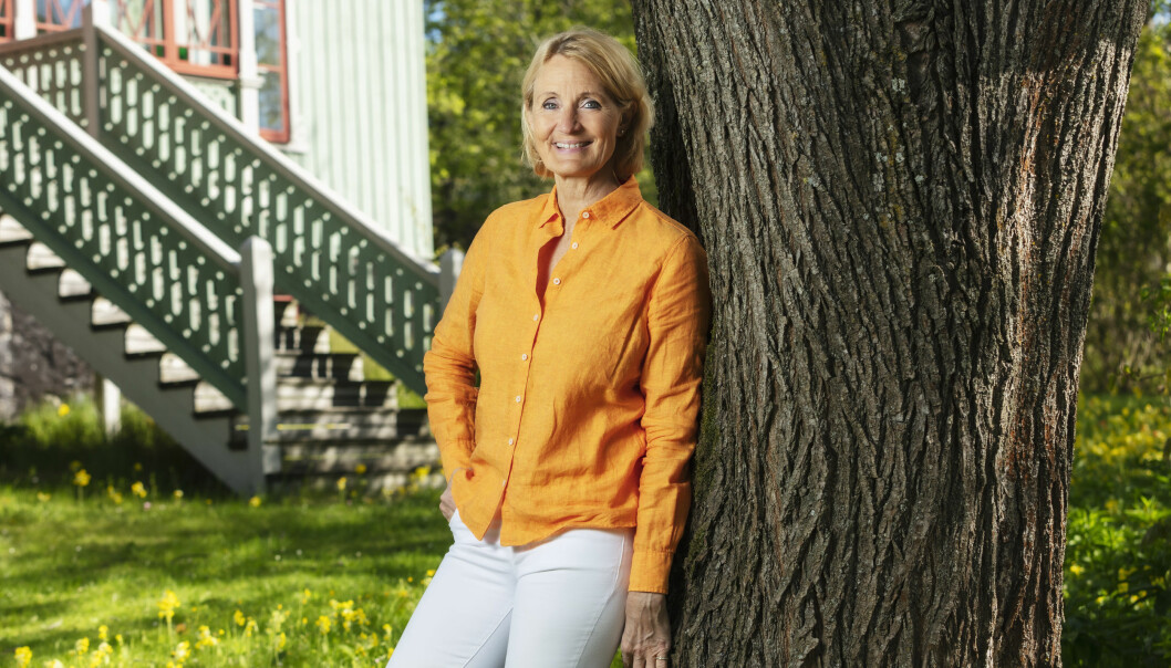 Sommar i P!-producenten Bibi Rödöö lutar sig mot en gammal trädstam.