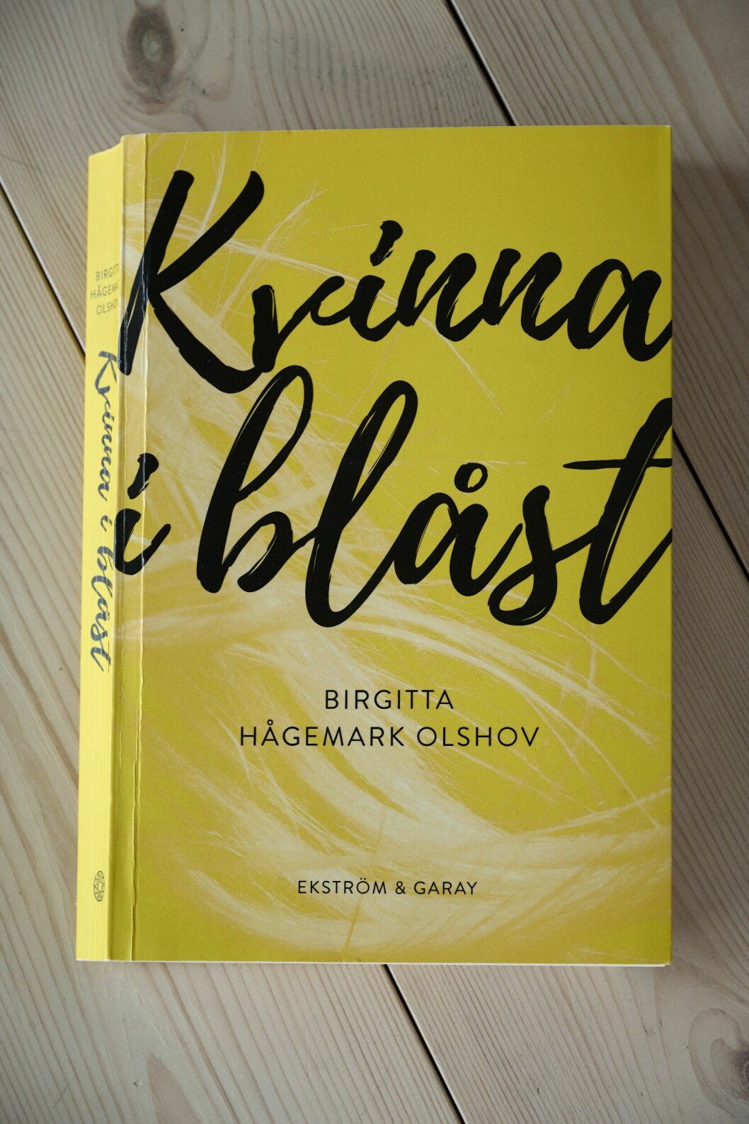 Birgitta Hågemark Olshovs bok Kvinna i blåst, med gult omslag och den svarta texten i skrivstil.