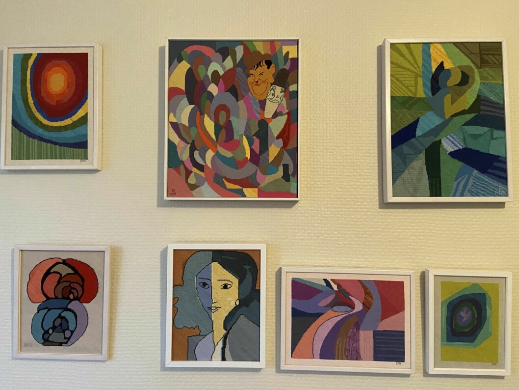 Birgittas son Micke var mycket konstnärlig och älskade att måla. Det här är tavlor som han målat och som Birgitta sedan broderat ovanpå. Mickes död blev ett trauma och en stor sorg. Sju färgglada broderade tavlor på väggen, med varierande motiv.