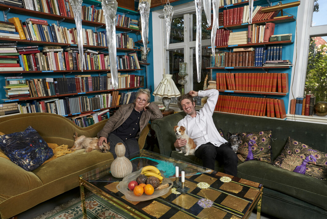Maggan och Peter sitter i en soffa i ett blått rum med massor av böcker