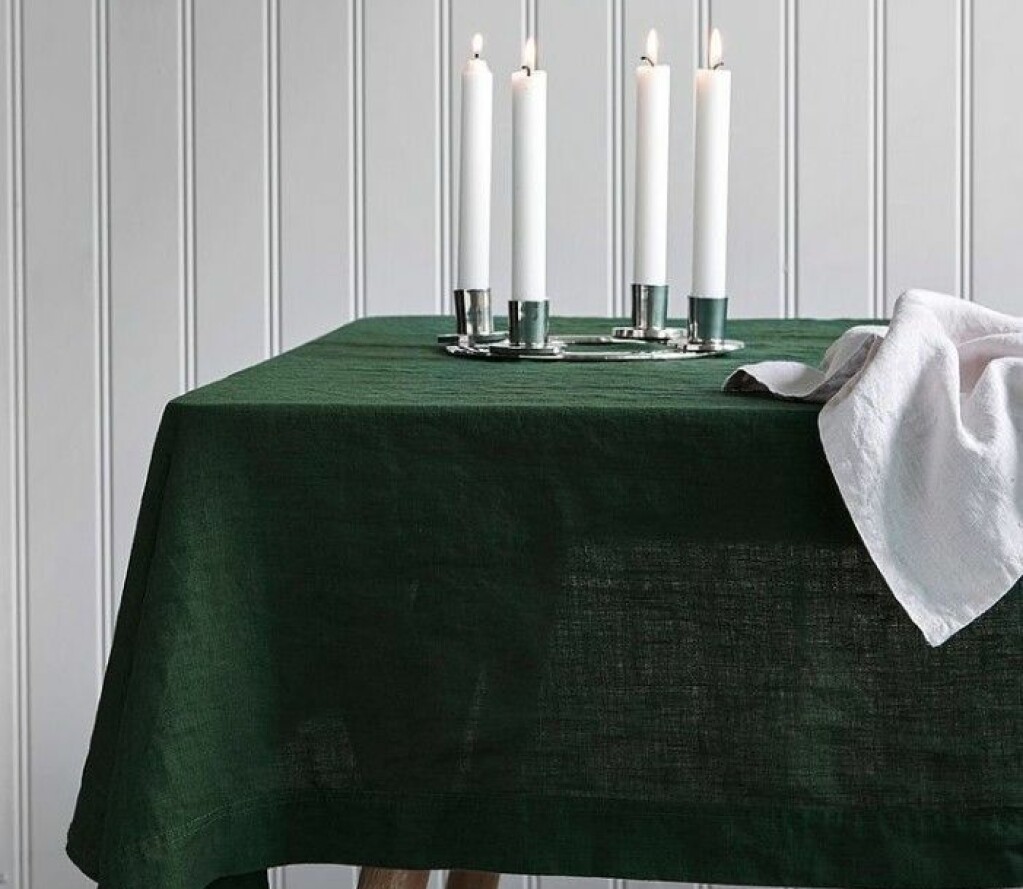 Bord med grön duk och levande ljus.