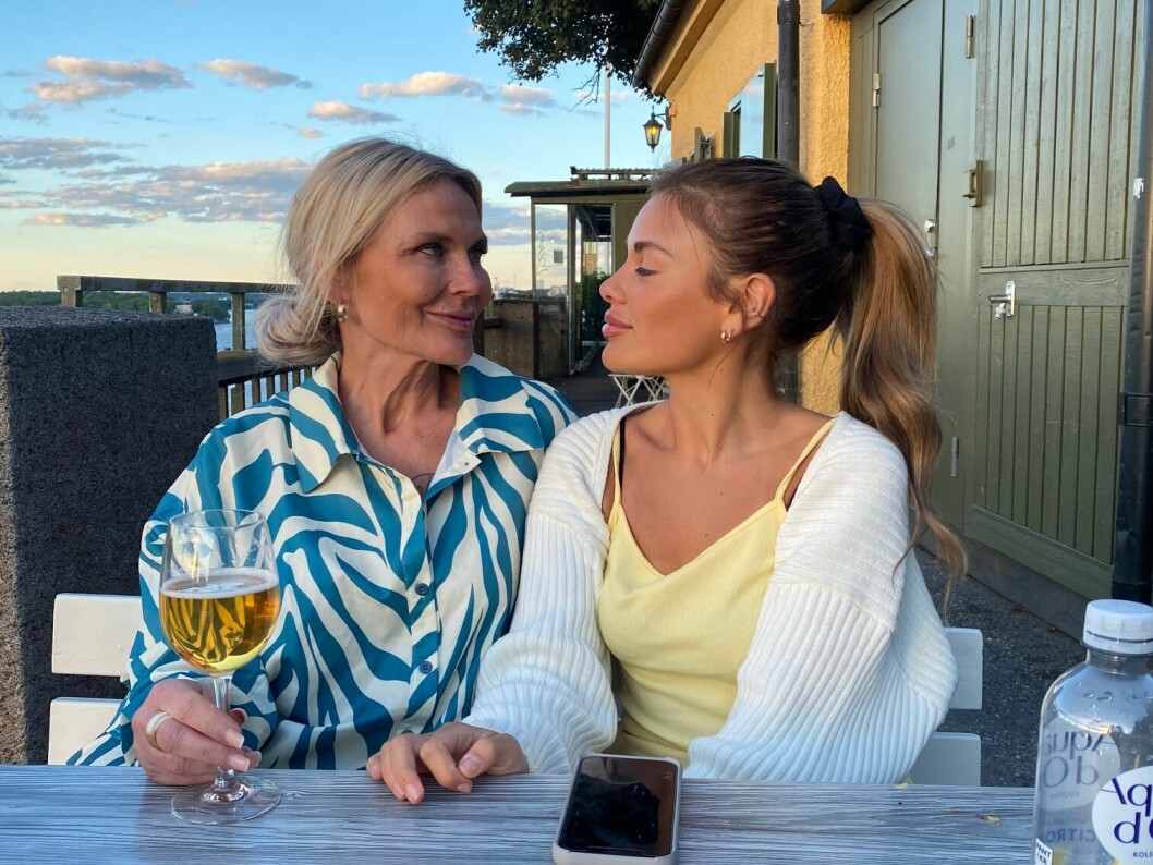 Camilla och Heaven sitter på en uteservering och ser glada ut.