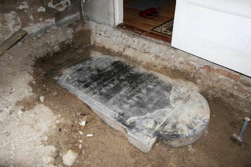 Familjen Nilsson hade ingen aning om att deras vardagsrum vilade på en gravsten. Fyndet under renoveringen fick snart media att gå igång. Gravstenen hittades under familjens golv