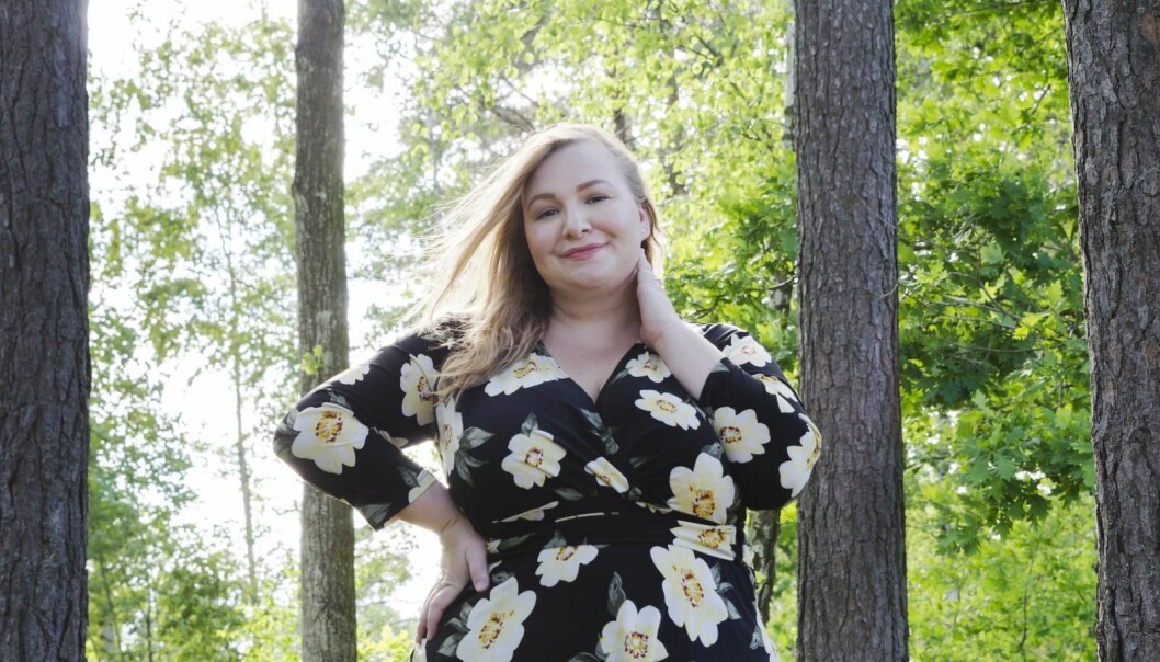 Nu vill Carolina sprida ett positivt budskap till andra, skjut inte upp livet i väntan på att bli smal. Carolina Almeborg står i skogen och ser glad ut,