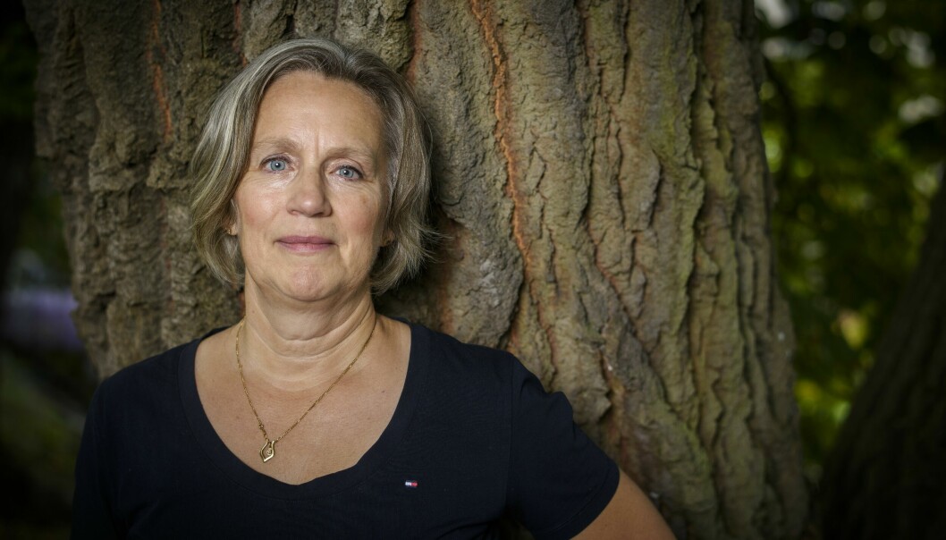 Parkinson-drabbade Cecilia Qwinth lutar sig mot ett träd.