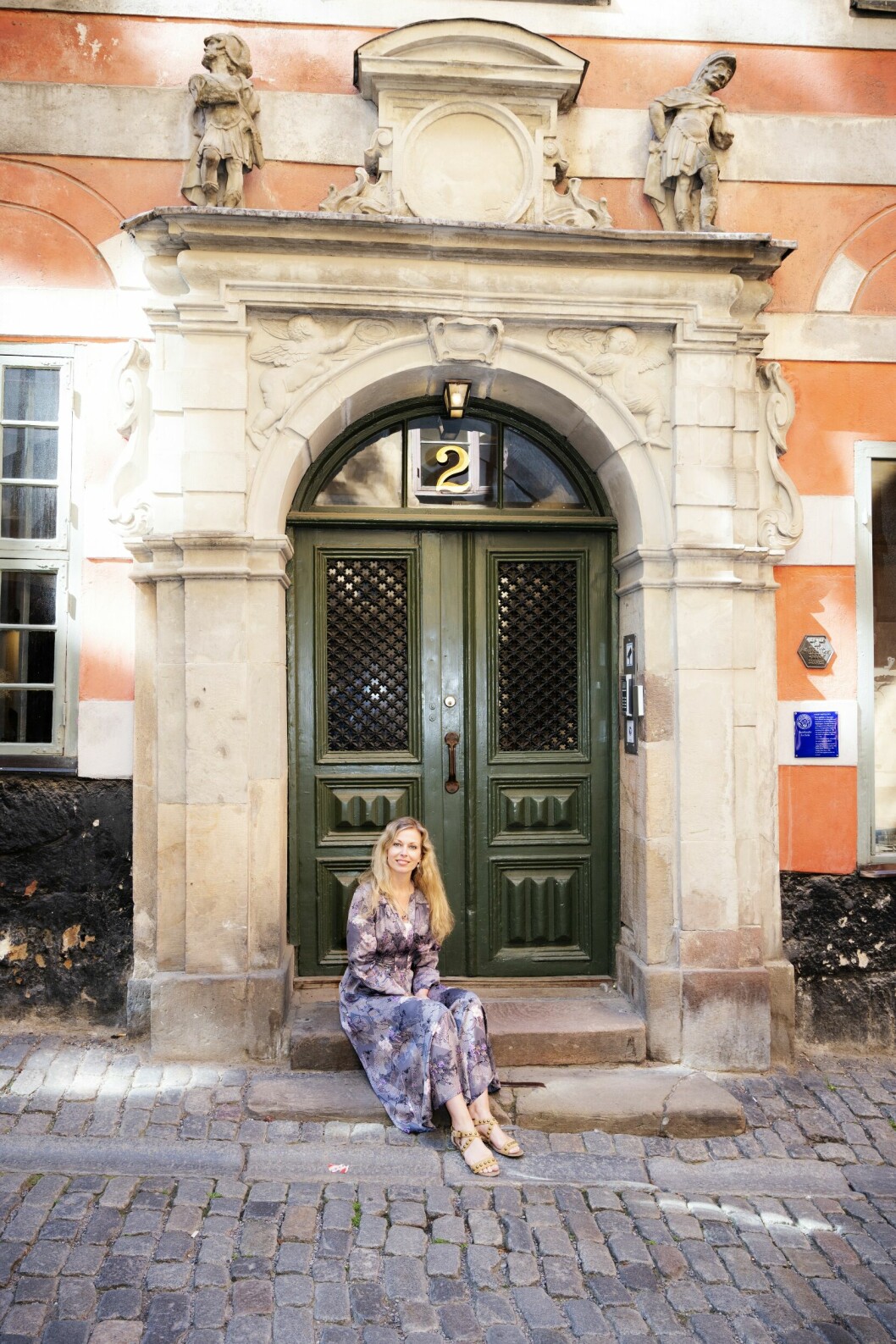 Ståtliga stadspalats och smala gränder. Cecilia hämtar mycket inspiration i Gamla stan, där hon också placerat huvudpersonen i sin bokserie Spöksyn. Cecilia Rojek sitter utanför ett pampigt stadspalats i Gamla stan.