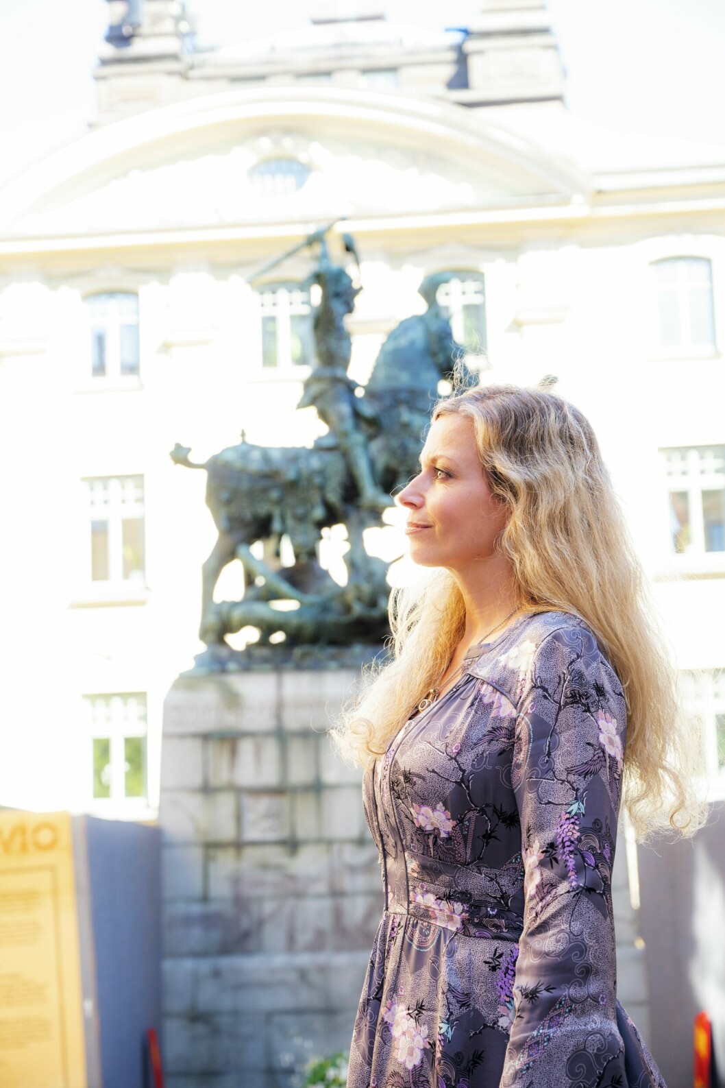 Cecilia Rojek framför statyn med Sankt Göran och draken i Gamla stan i Stockholm.