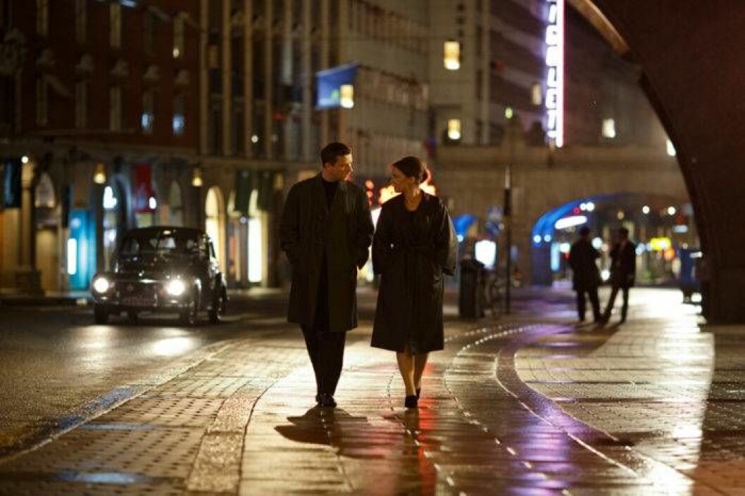 Calle Svensson (Charlie Gustafsson) och Nina Löwander (Hedda Stiernstedt) promenerar på Kungsgatan. Det är som bäddat för att en tidsdetektiv ska titta på Volvo PV:n för att avgöra årsmodell. Bild: Johan Paulin/SVT Calle och Hedda promenerar längs med Kungsgatan i Vår tid är nu