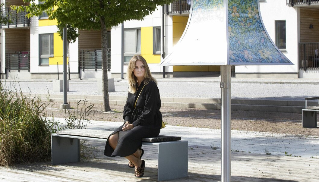 Clara Thysell allvarlig på en bänk i Gävle.