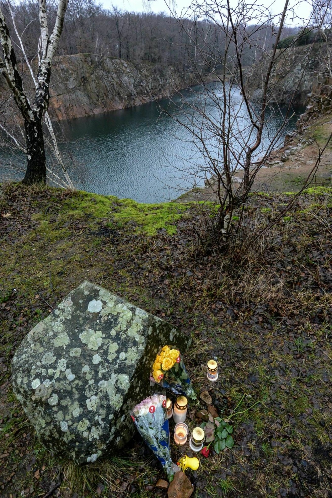 Pappan i Dalby dömdes för att ha dödat sin fru och sitt barn i stenbrottet. Foto: TT Blommor och gravljus vid Dalby stenbrott där en man kastade ner sin fru och lilla bebis.