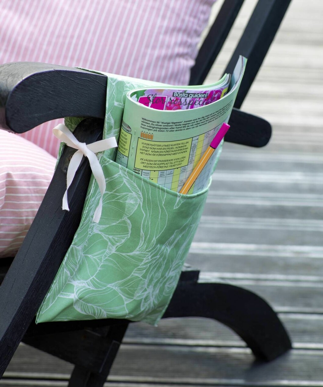 Stolsficka i grönt tyg med tidning i på trädgårdsstol 