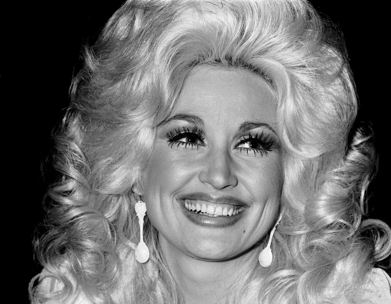 Stora, blonda peruker och mycket smink blev och har fortsatt vara en del av Dolly Partons image. Dolly Parton på 1970-talet.