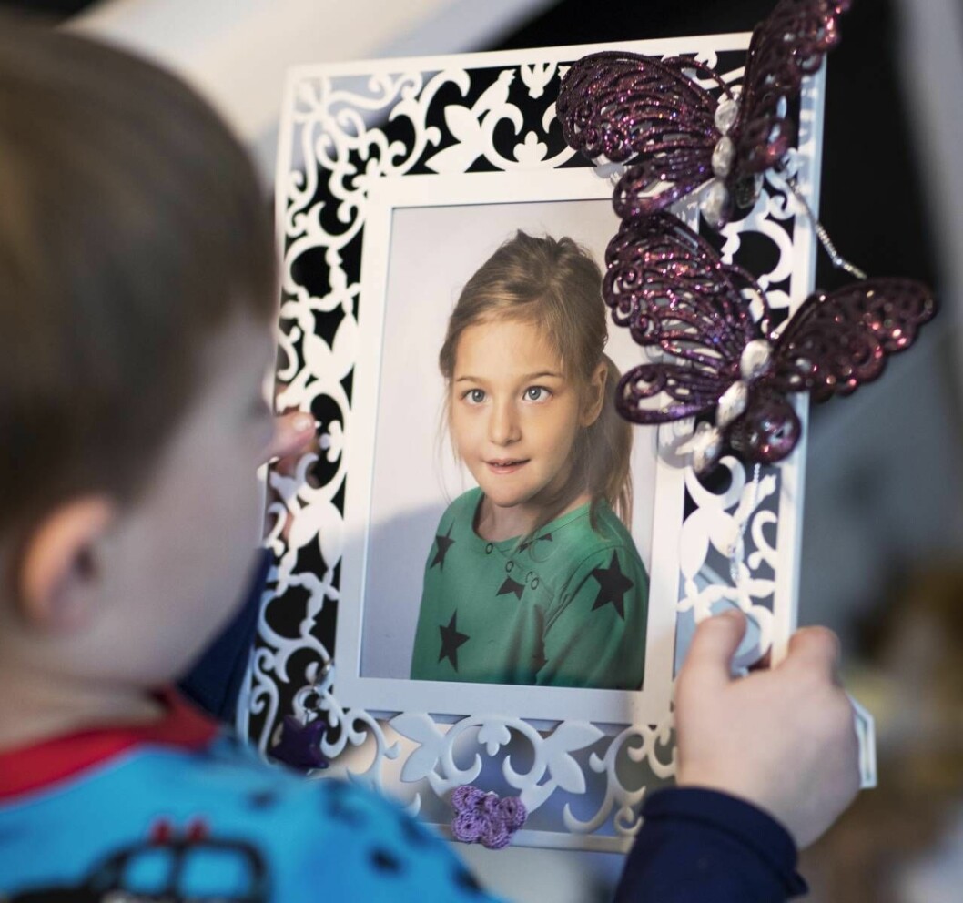 Milo med ett foto på Saga, storasystern han själv inte minns men har träffat. Foto: Veronica Kindblad Milo tittar på ett foto av storasyster.