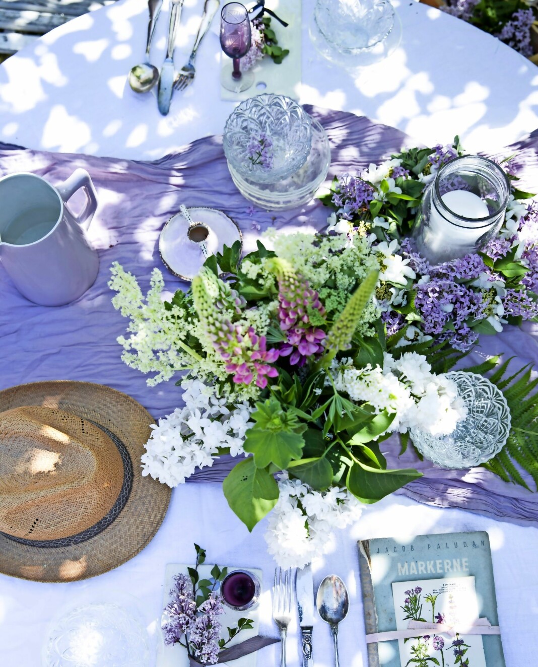 Duka med syrener och kombinera i vasen med både trädgårdsväxter och vild flora – lupin, daggkåpa, älgört och kirskål. Ett bord dukat med syrener.