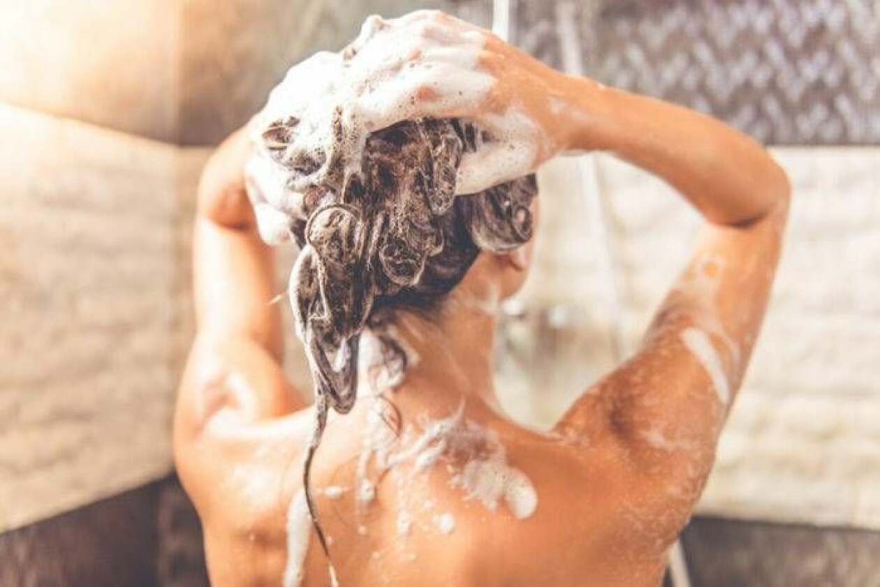 En kvinna schamponerar håret.