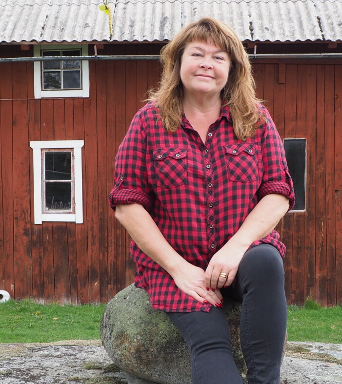 Eli Åhman Owetz framför logen hemma i Lilla Andersvedja. Författaren Eli Åhman Owetz i Norrtälje har skrivit åtta feelgoodromaner, den senaste heter En bättre människa.